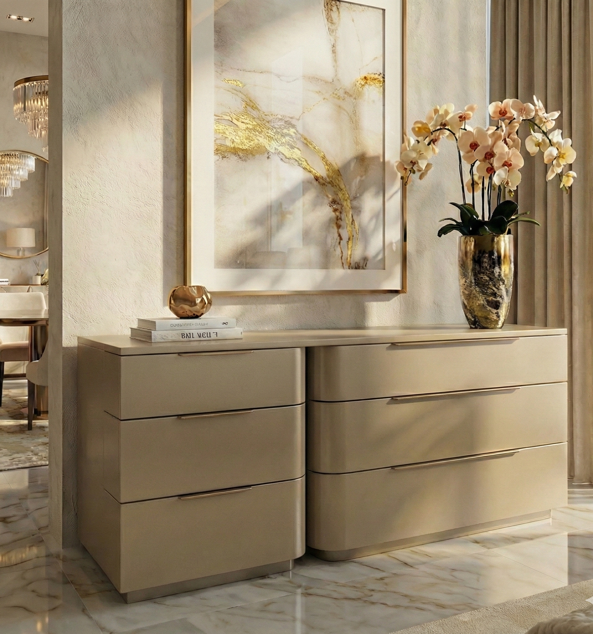 Close-up of a modern, luxury dresser in a smooth champagne finish, featuring a curved silhouette and sleek horizontal handles. The dresser is styled with a gold vase of orchids and decorative books, set against a backdrop of abstract art and marble flooring.