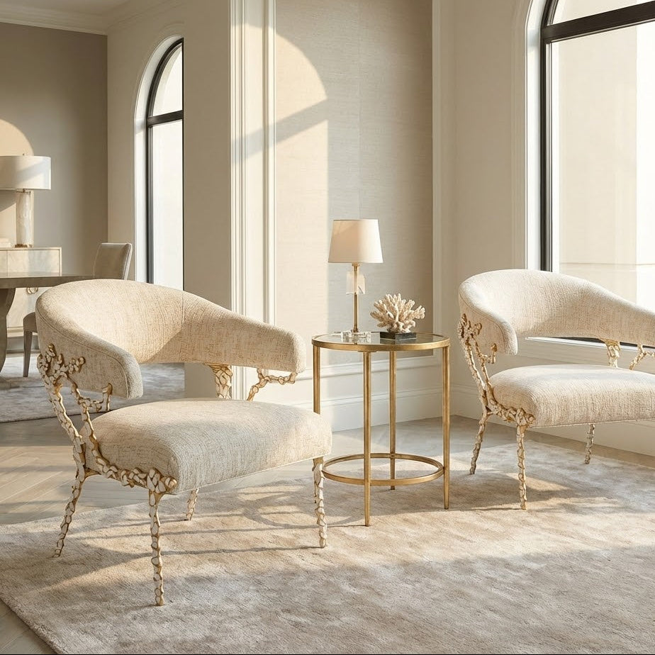 A statement armchair with a sculptural gold branch frame, styled in a bright, high-end living room with marble floors.