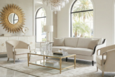 Modern living room with beige sofa, chairs, and a coffee table in a well-lit room.